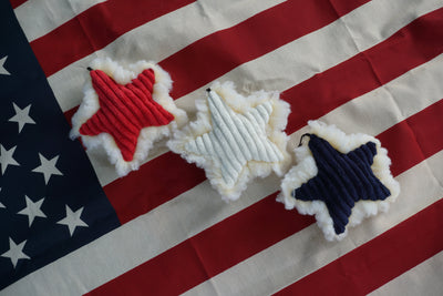 Three red, white, and blue HuggleFleece® stars laying on American flag