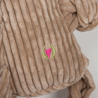 Close view of the HuggleHeart logo on Anteater plush dog toy back.