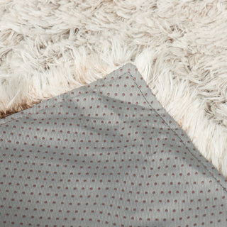 Close up view of the durable stitching used on the bottom of the soft and fluffy gray couch and bed protector.