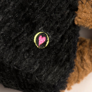 This is a photo of the HuggleHounds Heart. It is a raspberry colored heart in a lime green circle, this is the seal of authenticity for a HuggleHounds dog toy.