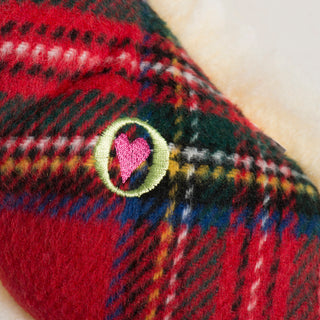 Close-up of embroidered pink heart detail on the red plaid tartan side of the HuggleFleece® Bone toy.