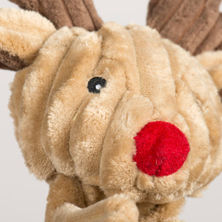 Close-up of the reindeer dog toy's face showing a fuzzy red nose and embroidered black eyes.