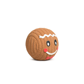 Side view of a gingerbread Ruff-TexÂź ball with smiling face and white icing details.