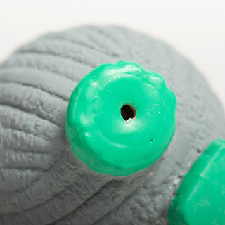 Bottom view of green feet of Ruff-TexÂź mouse toy with squeaker hole visible.