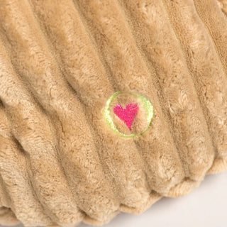 Detail view of the embroidered pink HuggleHeart on Rudy Reindeer Knottie's plush body.