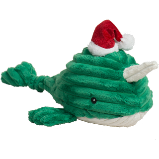 Angled front view of Noe Narwhal Knottie® plush toy with red Santa hat and white horn on green plush body.