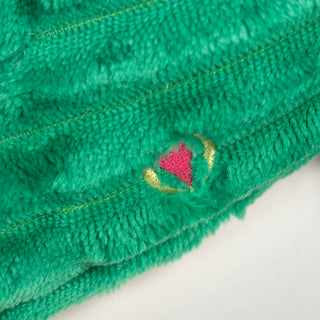 Close-up of Noe Narwhal Knottie® toy's pink embroidered heart detail, stitched onto the green corduroy fabric.