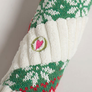 Close-up of embroidered pink heart logo on the white corduroy section of the candy cane dog toy.