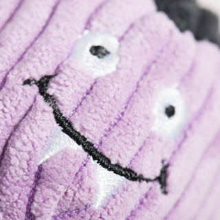 Close-up detail of purple vampire cat toy showing fangs and stitched smile
