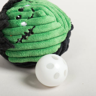 Green Frankenstein cat toy ball next to white plastic bell insert