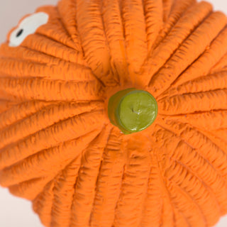Top-down close-up of Gourdie Ruff-Tex pumpkin toy showing bright green stem and textured orange surface.