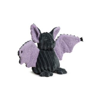 Side view of Baxter Bat plush toy seated with wings out, showing lavender wing fabric and dark grey corduroy body.