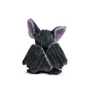 Front view of Baxter Bat sitting upright with wings wrapped around its body, showing large purple-lined ears.