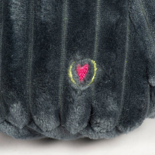 Close-up of a small embroidered pink heart outlined in yellow on soft, dark grey corduroy plush fabric.