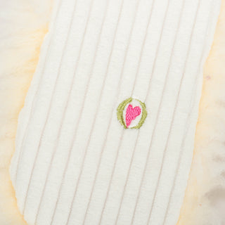 Close up of embroidered HuggleHeart logo on back of Louise Lamb Fluffer Long & Lovelie™.