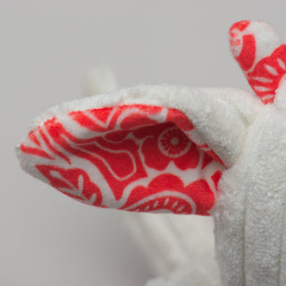 Close up of dragon's ear to show red and white floral pattern.