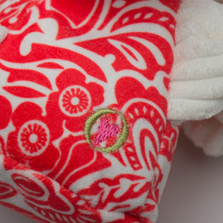 Close up of HuggleHeart logo on red and white floral fabric.