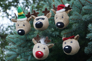 Lifestyle of five Santa's Reindeer Wee Huggles Balls hanging from evergreen tree.