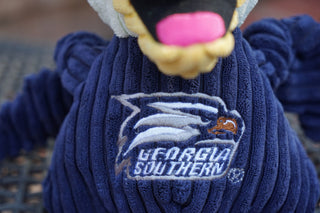Close up image of Georgia Southern University Gus the Eagle plush dog toys shirt: he has the university logo on it to show embroidery detail.
