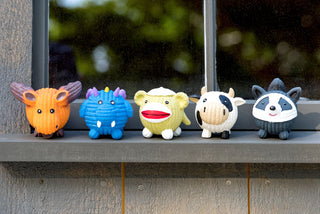 Moose, dragon, sock monkey, raccoon Ruff-Tex® balls sitting on a window sill. These are the toys that are inside the bucket. You get two of each.