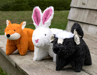 Set of three squishy bunny, fox, and skunk, shaped plush dog toys: Fox has orange fur, white furred inner-ear and mouth. Bunny has white fur, with pink inner-ears and nose. Skunk has black fur, with white hair, white inner-ear, and forehead.