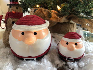 Set of two squeaky ball shaped santa dog toys: Has on his signature red and white hat, black eyes, large white beard, santa suit, and black boots.