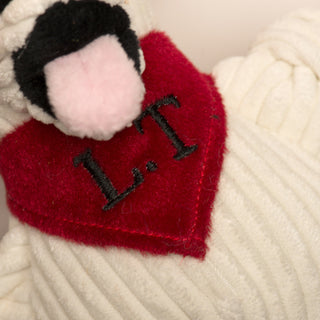 Close up image of red bandana around Chihuahua mix plush dog toy neck: has the initials "L.T".