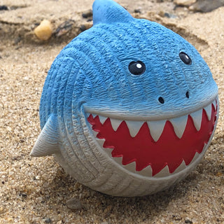 Finn Shark Ruff-Tex Ball in the wild, sitting on the beach.