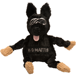 Black shepherd durable plush dog toy. Has black fur, has on a pair of silver goggles, black nose, pink tongue, black knotted limbs, light-brown paws, with the name "K-9 Mattis" across the chest, and is squeaky.