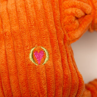 Close up of HuggleGroup Heart logo on back of Astronaut durable plush dog toy.