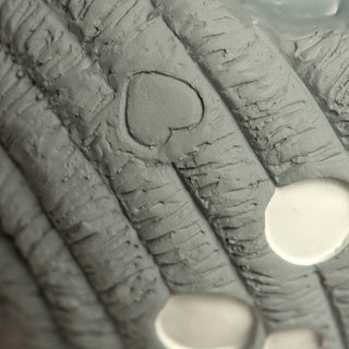 Close up of HuggleGroup heart logo on moon squeak ball dog toy.