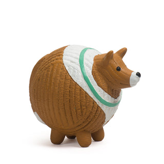 Side view of brown and white collie with green collar squeaky latex ball dog toy.
