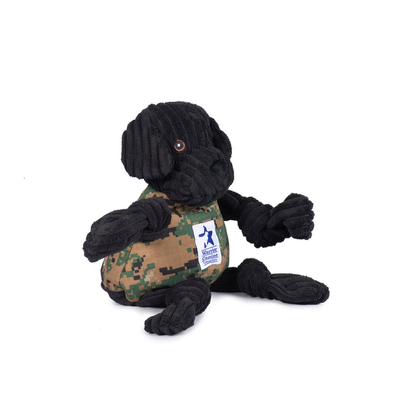 Side view of Warrior Canine Connection Luke Lab Knottie. Black corduroy head and limbs, with brown open eyesand floppy ears. Camo body, with white Warrior Canine Connection logo in the middle.