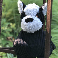 Lifestyle photo of Bruiser HuggleMutt. Pictured outside in a field near an iron bar. Thumbnail