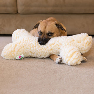 Dog biting fluffy natural cream colored HuggleFleece® two foot bone with squeaker.