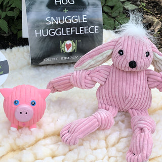 Set of three natural colored mat, squeaky ball shaped pig dog toy, and bunny shaped plush dog toy: Pig has pink fur, light-pink nose, and white feet. The bunny has white hair, pink fur, white inner-ear, and pink knotted limbs. The mat is in the color natural and is in the size extra small.