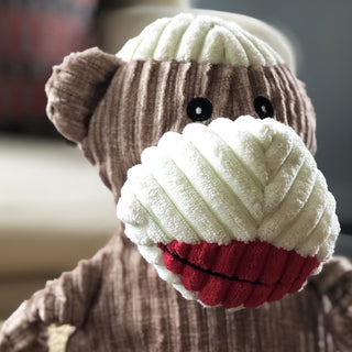 Close up of brown and white sock monkey durable plush corduroy dog toy's face to show detail of corduroy fabric.