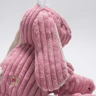 Side view of pink bunny durable plush corduroy dog toy with white hair and ears.