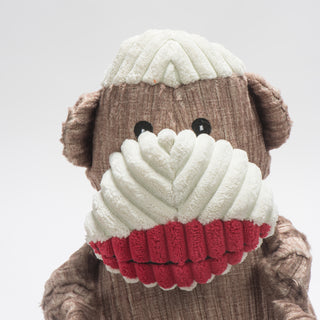 Close up to show texture of corduroy fabric. Brown and white sock monkey durable plush corduroy dog toy with knotted limbs, white top of head, face, and big red lips.