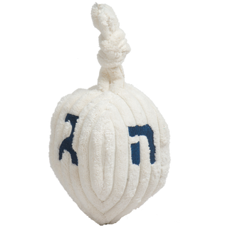 Dreidel shaped plush dog toy: has white knotted top, with the Hebrew scripts on each of the four sides embroidered in blue.