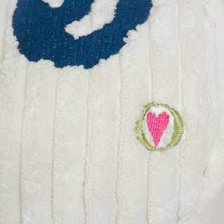 Close up image of HuggleGroup logo on white dreidel plush dog toy.
