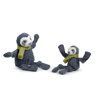 Two plush sloths with knitted sweaters on a white background