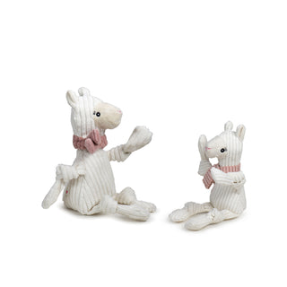 Set of two Llama shaped plush dog toys:  has white body and limbs, beige face, black eyes, white pupils, light-pink scarf, knotted arms and legs, and is squeaky. 