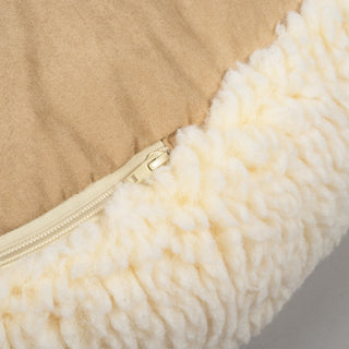 Close up view of zipper on natural colored fluffy bed. 