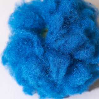 Close-up of blue wool roving on a white background