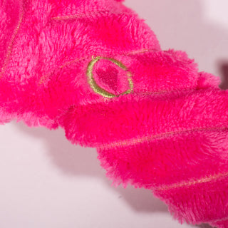 Close up view of HuggleHeart promise heart on magenta Axolotl dog toy. 