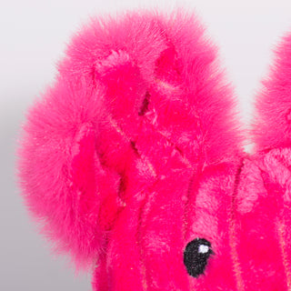 Close up view of magenta furred Axolotl plush dog toy fluffy ear. 