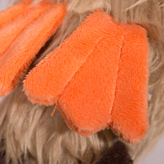 Close up view of orange feet on duck shaped plush dog toy. 