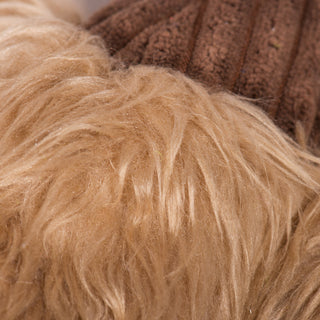 Close up view of brown furred body on duck shaped plush dog toy. 