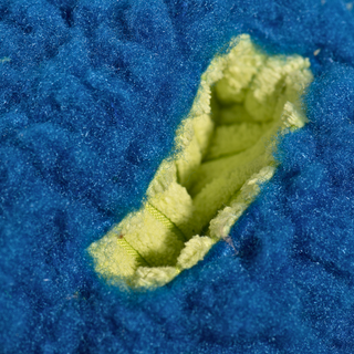 Close-up of the treat-trapper ball, showing one of the three green holes designed to hide treats inside for your dog to discover.